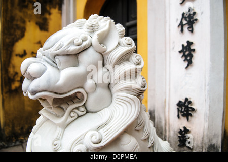 HANOI, Vietnam — vue de côté d'un lion en marbre blanc richement sculpté garde l'entrée d'une porte à la pagode One Pillar à côté du musée Ho Chi Minh dans le quartier Da Binh de Hanoi, Vietnam. Banque D'Images