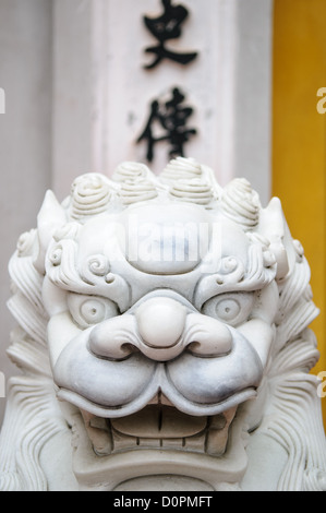 Les lions en marbre blanc richement sculptées gardent l'entrée d'une porte à la Pagode au Pilier à côté du musée de Ho Chi Minh dans le quartier de Binh Da Hanoi, Vietnam. Banque D'Images