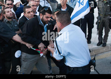 Jérusalem, Israël. 29 novembre 2012. La police en uniforme et des détectives de force pour arracher un drapeau palestinien de manifestants de droite pour l'empêcher d'être brûlé en signe de protestation. Jérusalem, Israël. 29-Nov-2012. MKs Michael Ben-Ari et Aryeh Eldad, de l'extrême droite Parti Otzma Leyisrael, conduire les activistes dans un drapeau palestinien tentative de gravure au bâtiment des Nations Unies à Jérusalem manifestant contre un État palestinien offre à l'Assemblée générale des Nations Unies à New York. Banque D'Images