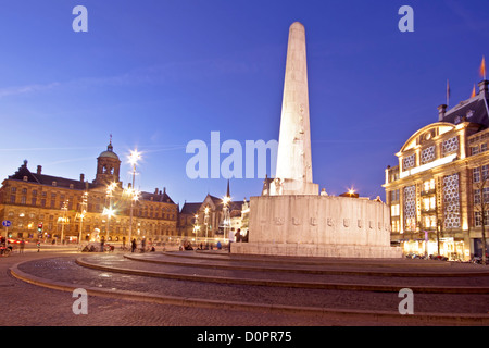 Le Monument National sur le barrage et à l'arrière-plan le Palais Royal à Amsterdam aux Pays-Bas au crépuscule Banque D'Images