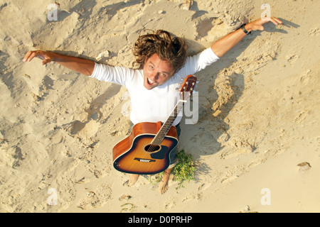 Joueur de guitare dans le sable sur la plage Banque D'Images