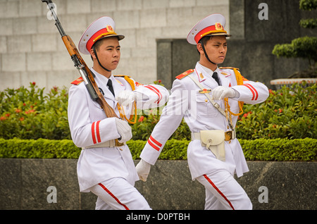 Gardes d'honneur du Mausolée de Ho Chi Minh Hanoi Vietnam // HANOI, Vietnam — des gardes en uniformes de cérémonie blancs se tiennent au Mausolée de Ho Chi Minh, le dernier lieu de repos du leader révolutionnaire et premier président du Vietnam. La structure en granit, achevée en 1975, abrite le corps préservé de Hô Chi Minh, qui a dirigé le mouvement d'indépendance du Vietnam contre la domination coloniale française et plus tard contre les forces américaines pendant la guerre du Vietnam. Situé sur la place Ba Dinh dans le centre de Hanoi, le mausolée est l'un des monuments nationaux les plus importants du Vietnam. Le site attire des milliers de visiteurs annuellement Banque D'Images