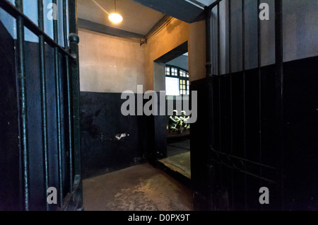 HANOI, Vietnam — Une vue à travers un couloir dans la prison de Hoa Lo. À travers les portes de fer, on peut voir des mannequins en plastique illustrant les conditions dans lesquelles les prisonniers étaient détenus par le gouvernement colonial français. La prison est mieux connue en Occident sous le nom de Hanoi Hilton, l'endroit où les pilotes américains ont été gardés comme prisonniers de guerre pendant la guerre du Vietnam. Banque D'Images