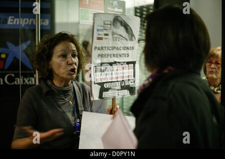 29 novembre 2012, Barcelone, Espagne. Plate-forme des personnes touchées par des stocks optimale occupent un bureau de 'La Caixa' bank à Barcelone, Espagne. Sur cette photo un des protestataires expliquant leur situation à un client de la banque. Crédit : esteban mora / Alamy Live News Banque D'Images