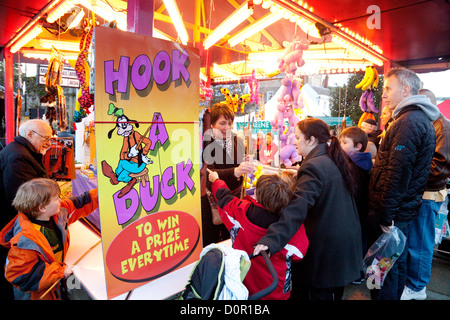 Les parents et enfants jouant un canard crochet, la foire de Noël de Bury St Edmunds, Suffolk, UK Banque D'Images