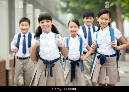 Belle écoliers en uniforme sur le chemin de l'école Banque D'Images