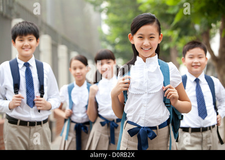 Belle écoliers en uniforme sur le chemin de l'école Banque D'Images