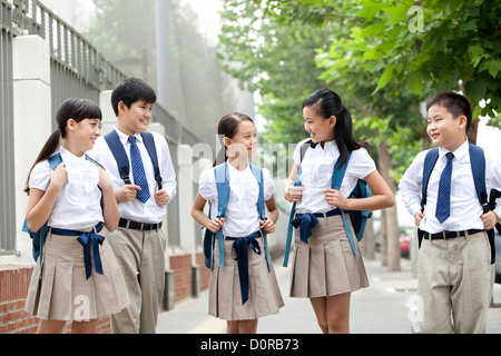 Belle écoliers en uniforme sur le chemin de l'école Banque D'Images