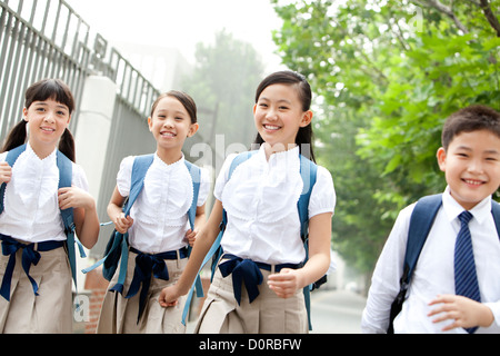 Belle écoliers en uniforme sur le chemin de l'école Banque D'Images