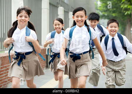 Des écoliers en uniforme sur le chemin de l'école Banque D'Images