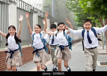 Des écoliers en uniforme sur le chemin de l'école Banque D'Images