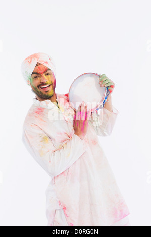 Portrait d'un homme jouant du tambourin sur Holi Banque D'Images