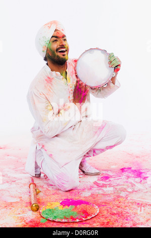 Homme jouant du tambourin sur Holi Banque D'Images