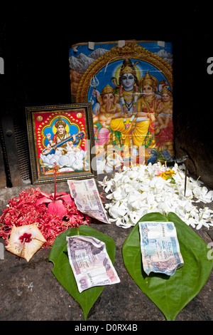 L'argent et des offrandes de fleurs. Sanctuaire hindou. Polonnaruwa. Sri Lanka Banque D'Images