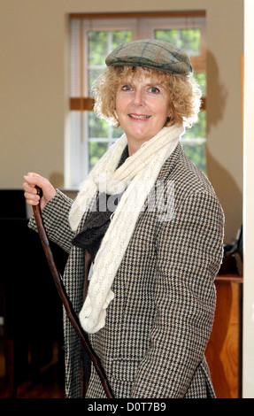 Femme d'âge moyen portant un mens Harris Tweed veste et casquette avec de vieux bâton de marche - Photo de Simon Dack Banque D'Images