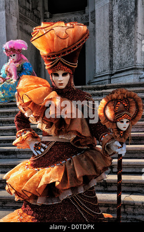 Femme masquée sur les marches de la basilique Santa Maria della Salute pendant le Carnaval de Venise, Italie Banque D'Images