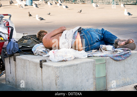 Homeless man sleeping on bench Banque D'Images