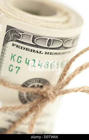 Rouleau de One Hundred Dollar Bills attachés en jute String isolé sur un fond blanc. Banque D'Images