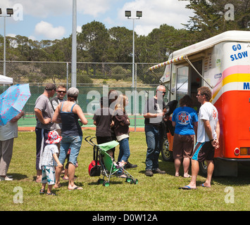 Les familles la queue pour acheter des glaces à une glace van. Mangawhai, Northland, Nouvelle-Zélande, île du Nord. Banque D'Images