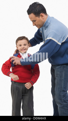 L'homme s'habille son fils pour l'école Banque D'Images