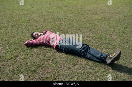 Homme étendu dans une pelouse Banque D'Images