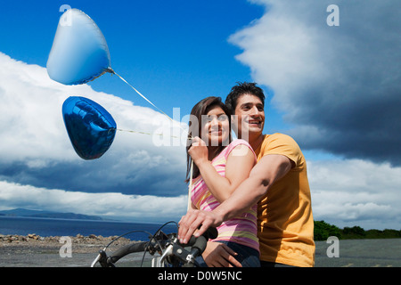 Couple riding a bicycle dans un jardin le long d'une côte Banque D'Images