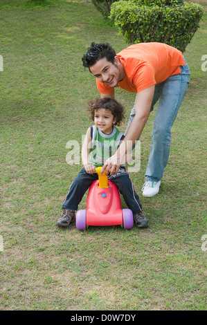 Homme jouant avec son fils dans un jardin Banque D'Images