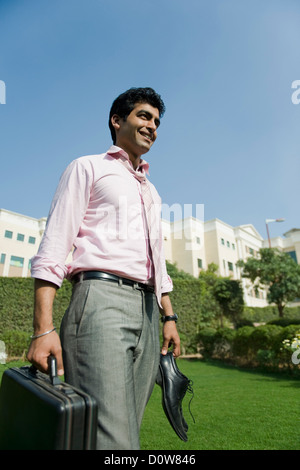 Businessman walking in a park, Gurgaon, Haryana, Inde Banque D'Images