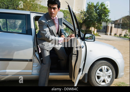 Businessman sortir d'une voiture, Gurgaon, Haryana, Inde Banque D'Images