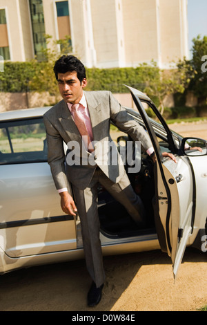 Businessman sortir d'une voiture, Gurgaon, Haryana, Inde Banque D'Images