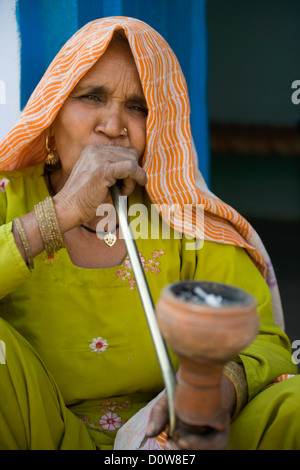 Femme fumant un narguilé pipe, Farrukh Nagar, Gurgaon, Haryana, Inde Banque D'Images