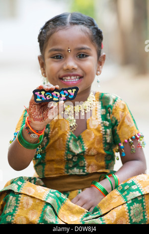 Smiling Indian girl holding a Happy broderie multicolore patch. L'Andhra Pradesh, Inde Banque D'Images