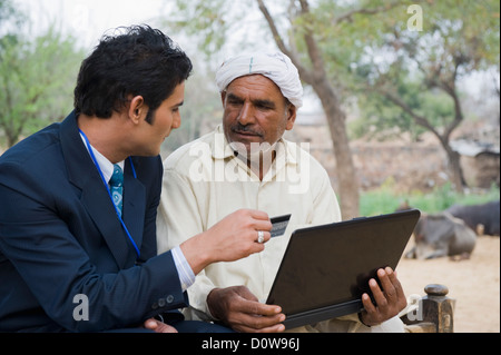 Conseiller financier d'expliquer à un agriculteur au sujet de l'agriculture, de prêt, de l'Haryana, Inde Hasanpur Banque D'Images