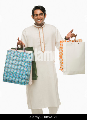 Bengali man carrying shopping bags and smiling Banque D'Images