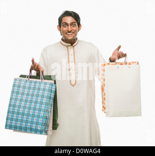 Bengali man carrying shopping bags and smiling Banque D'Images