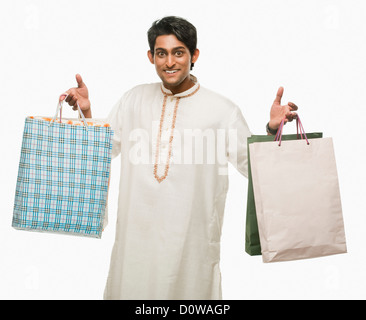 Bengali man carrying shopping bags and smiling Banque D'Images