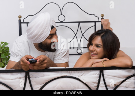 Couple Sikh couché sur le lit et regarder Banque D'Images