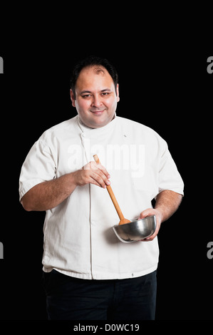 Portrait d'un chef holding un bol et une cuillère en bois Banque D'Images