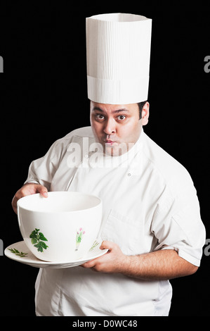 Chef holding une grande tasse Banque D'Images