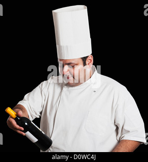 Chef looking at wine bottle Banque D'Images