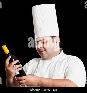 Chef looking at wine bottle Banque D'Images