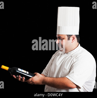 Chef looking at wine bottle Banque D'Images