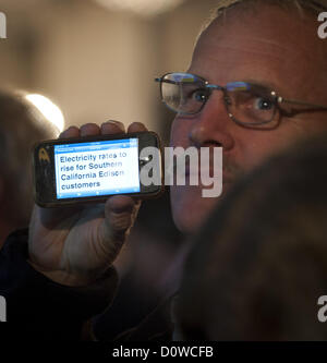 30 novembre 2012 - Laguna Hills, California, USA - un membre de l'assistance utilise son téléphone mobile pour envoyer un message comme il est filmé par une équipe de télévision le vendredi soir. Dans la dernière de plusieurs réunions publiques, les chansons ont rencontré dans un forum public avec des représentants de la Commission de la réglementation nucléaire afin de répondre aux questions de sécurité mécanique avec l'unité 2 générateurs de vapeur vendredi soir à Laguna Hills. Environ 380 personnes ont assisté à la réunion de 4 heures qui a commencé CHANSONS VP of Engineering à la tête d'une explication détaillée de ce qui a causé des défaillances de tubes pour générateurs de vapeur. Chansons est proposin Banque D'Images