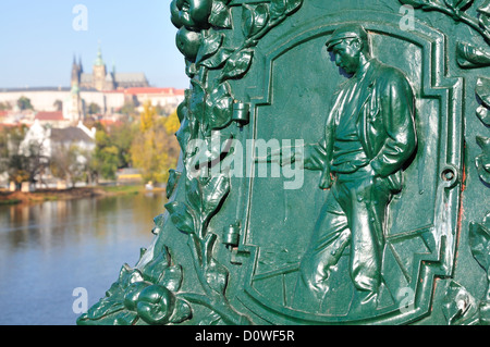 Prague, République tchèque. Détail de la base de la lampe sur la plupart legii / pont des légions (1901). Château et la cathédrale derrière Banque D'Images