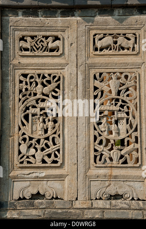 Deux fenêtres en brique sculptée d'une vieille maison chinoise Banque D'Images