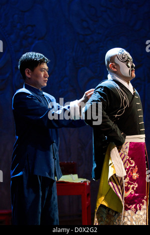 Un personnage principal masculin étant aidé par un assistant pour attacher sa robe avant d'une salle de spectacles de l'Opéra de Pékin à Beijing, Chine Banque D'Images