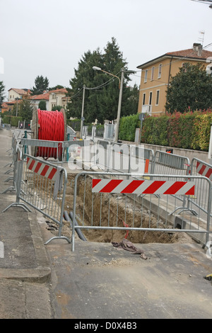 Les travaux routiers avec un énorme d'excavation pour la pose de câble d'alimentation haute tension Banque D'Images