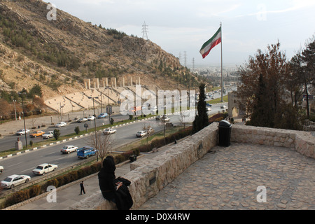 Une jeune femme iranienne regarde vers Coran Portail, une porte historique dans le sud du centre-ville persane de Shiraz, en Iran. Banque D'Images