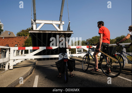 Les cyclistes en attente par pont à bascule, les Pays-Bas Banque D'Images