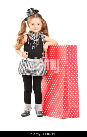 Portrait d'une jeune fille posant à côté d'un sac shopping isolé sur fond blanc Banque D'Images
